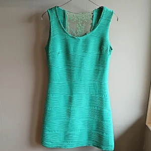 Festklänning - Figursydd klänning med spetsdetaljer i ryggen