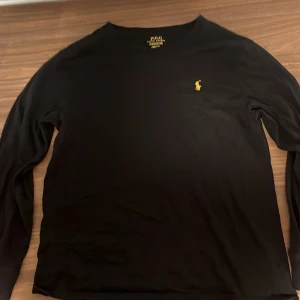 Ralph Lauren tröja - Säljer denna svart guldiga ralph lauren. Storlek S (barn). Väldigt bra, inga hål. Kan ta bytan annars. Nypris runt 1500kr. Kom vid fler bilder eller frågor
