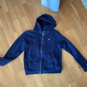 Lacoste tröja  - Mörkblå Lacoste i ny skick, strl 164 men skulle säga att den sitter som S, har själv M och den är lite liten för mig
