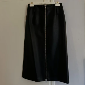 Läderkjol midi - Figursydd läder(faux) kjol från H&M, med dragkedja så man kan välja hur öppen man vill ha den på! Den är stretchiga så väldigt bekväm att ha på sig. Använd 1 gång, väldigt bra skick, ordinarie pris 499kr