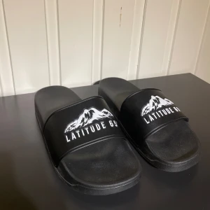 LATITUDE 65 TOFFLOR🍾 - Säljer nu dessa sjukt feta Latitud 65 tofflor i storlek 43!!🍾🎉 Dessa är sjukt limiterade och nästintill omöjliga att få tag på!!🎉 Skick är 10/10 Hör av dig vid prisförslag 🎉