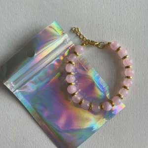 Egengjort pärlarmband  - Egengjort pärlarmband med rosa och guldiga pärlor. 