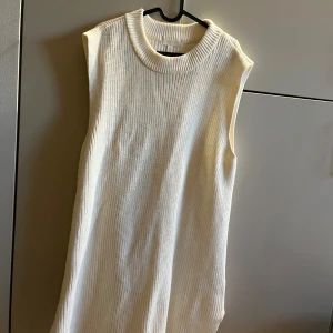 Vit stickad klänning från HM - Knappt använd vit stickad ”västklänning” från HM. Storlek L och perfekt till sensommar/höst.
