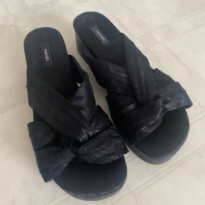 Tofflor Mango 38 - Svarta ”siden” tofflor/träklackar/slip ins/sommarskor. Storlek 38, passar smal fot!  Skulle tro de passar 37 också då de är lite mindre i storlek.