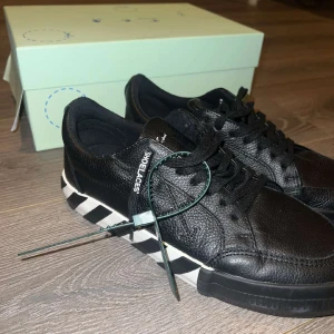 Black Low Vulcanized Off White Skor - nya “Off White” skor köpta i augusti 2023 och har bara testats och använts en gång utanför, därför är undersidan av skorna lite smutsiga. Skicket är perfekt. Jag säljer dem eftersom de inte passar min stil och jag använder dem inte alls. Kvitto finns