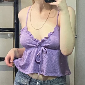 Lila luftig topp - Alldrig använd och har prislappen kvar då den är för stor, köparen väljer själv ifall jag ska ta bort prislappen för att tvätta eller inte inför ivägskickning. Materialet är texturerat men väldigt luftigt.