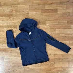 Nike Tech Fleece - Navy/Svart Barn - Tröja stl L, junior stl 147-158 cm Nike tech fleece i nyskick. Säljs då sonen vuxit ur den, nypris 1099kr