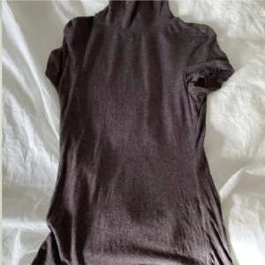 Vintage topp - T-shirt med polo. Tight modell i strl S men har mycket stretch i sig. Gammal tröja men i fint skick. Perfekta basic tröjan helt enkelt.