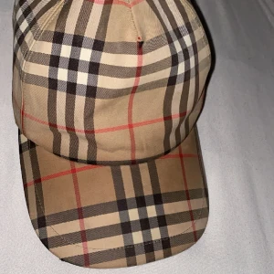 burberry keps - säljer min burberry keps, den är i bra skick men lite sönder där bak men inget man tänker på. skriv för fler bilder eller frågor. vid köp tryck gärna på köp nu. låda kommer inte med. Nypris 3000 men pris går att diskutera 