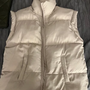 Beige puffer väst  - Beige väst från Gina Tricot. Aldrig använd. Storlek 158/164 men passar mig som brukar ha S/M ❤️ passar L också