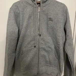 Burberry Zip kofta  - Fin Grå burberry Zip kofta! I väldigt bra skick nästan aldrig använt, har tagit hand om den jätte så inga fläckar eller något liknande på den. Kom med prisförslag byten funkar också 😃