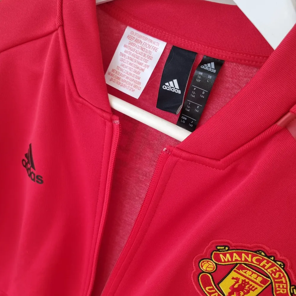 Ziptröja från Adidas, skick som ny. Manchester United tryck på ryggen och emblem på bröstet.. Tröjor & Koftor.