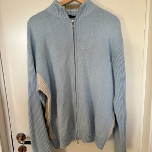 Blå kofta - Ljusblå kofta, färgen ser lite smutsig ut på bild men är en mycket finare blå i verkligheten.