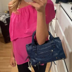 Rosa off-shoulder topp - En rosa off-shoulder topp med en lös passform. Toppen har en volangdetalj runt halsen och är ärmlös.