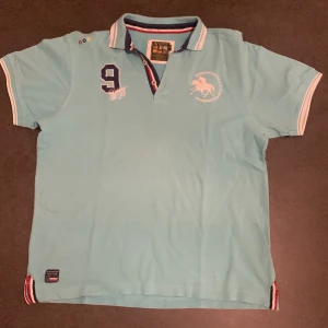 Ralph lauren pikétröja  - Turkos Ralph lauren pikétröja med huntington polo club knappar uppe vid halsen. Jätte snygg och stilig pikétröja.