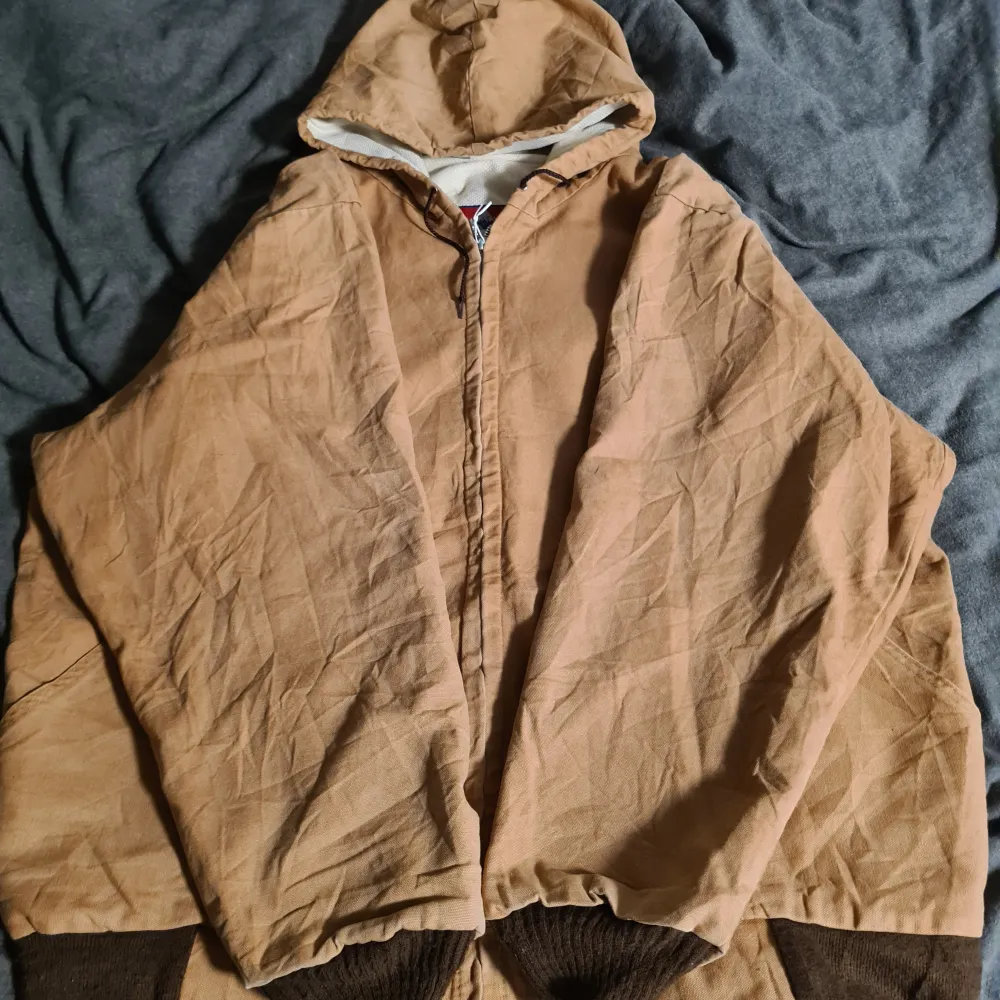 XL, 1990-2000s arbetsjacka, carhartt liknande, made in USA.  Superfrän vintage arbetsjacka för dig som vill ha komforten av en carhartt för 1/4 av priset. Sitter stort och har en liten slitning på axeln. Passar perfekt för dig som söker retro looken!. Jackor.