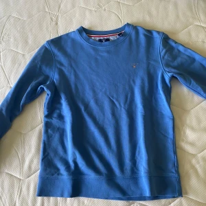 Blå långärmad tröja - En blå långärmad tröja med rund halsringning. Tröjan har en enkel design utan mönster och är tillverkad i ett mjukt material.