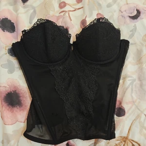 Bustier corset top - Sjukt snygg bustier corset top. Storlek 75C i bysten. Fin spets och diamant detaljer. Finns en liten defekt på framsidan där det finns två hål, annars är det knappt synligt eftersom det finns två lager av tyg som gömmer defekten. 💞