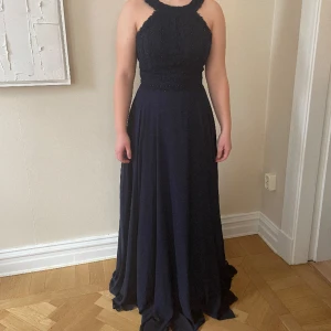 Balklänning  - Säljer min syrras balklänning från Jora collection  Mörkblå klänning med skrimrande stenar , inbyggd bh vilket gör att du inte behöver något annat stöd  Storlek 38  Inköpt i Remmans högtider i Göteborg  Aldrig använd pga corona  Nypris 3500 