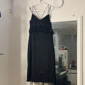Volangklänning - Svart volangklänning med kors i ryggen💕 Väldigt fin till sommaren eller som festklänning. Storlek S, men kan också passa M då den är relativt stor vid bysten. Köpt på Zalando (märket Pieces) med nypris 499kr för ett par år sen, men har knappt använts