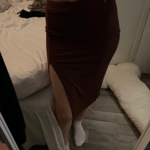 Lång kjol med slits - Aldrig använd. Är i storlek XS men passar även S/M då den är väldigt stretchig 