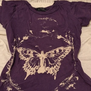 Grunge  - En kortärmad t-shirt i en mörk lila färg med ett mönster av en fjäril. Storleken är 146/152. Inga synliga hål eller fläckar 💕 Sista bilden är lite suddig