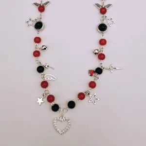 Röda och svarta glaspärlor, silverdetaljer (ej äkta silver), justerbart halsband. 