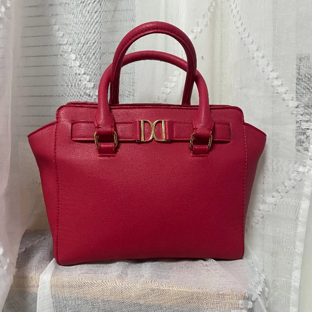 Röd väska från Don Donna! Säljer för den inte kommer till användning. Har endast använt den EN GÅNG! Frakten ingår! Kommer med väskband! Köpte för 400kr. Väskor.