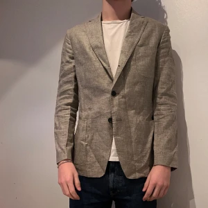 Linne kavaj - Snygg mörk beige kavaj i linne. Kavajen är en mindre 54 och därför passar inte mig. Snålt använd och därmed i ny skick. 