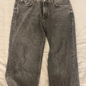 Svarta jeans  - Svarta/gråa Gina jeans. Dem sitter lite tightare vid låren och är mer utsvängda vid vaderna. Är lite sliten längst ned vid fötterna men är inget som syns på.