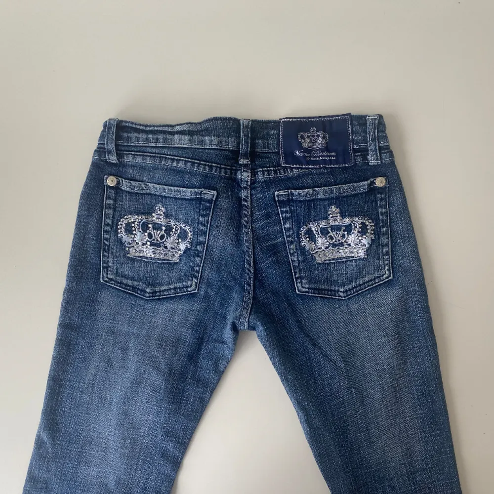 Lågmidjade bootcut Victoria Beckham jeans med vit krona och palieter. Jätte snygga, köpte de på plick men de passade inte. Midja: 36 cm    Innerbenslängd: 76cm    Skirv gärna om ni har frågor👑. Jeans & Byxor.