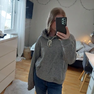 Grå hoddie - Grå hoodie med vitt snöre och ficka. Täcken på användning men annars bra kvalitet. Passar bpde Xs och S, då den är lite oversized. ❤  Pris kan diskuteras 