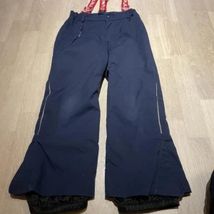 Reima skidbyxor 128 - Reimatec skidbyxor i mycket bra skick. Mörkblå. Endast tvättade enligt tvättråd. Rök- och djurfritt hem.