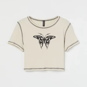 Beige top  - Crop top från H&M med fjärils-tryck på, storlek M. Säljs för den inte kommer till användning längre :)