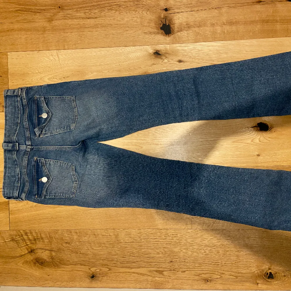 Blåa lågmidjade utsvängda jeans från H&M! Jätte snygga fickor där bak och fram. Har band så man kan justera storleken i midjan. Jätte trendiga och snygga! Storlek 164 men passar som S.  Köparen står för frakten 🥰. Jeans & Byxor.