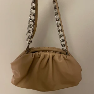 Väska - Beige väska från nakd, finns två olika remmar och går att ta bort båda🫶🏻finns en liten defekt (se sista bilden) annars jättefint skick!