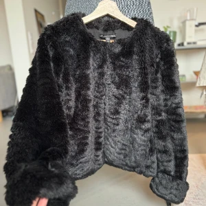 Fuskpäls Zara  - Svart fuskpäls från zara i strl M, lite mindre i modellen så passar S bra med. Fickor på båda sidor. Använd men i bra skick. Uppvikt ärm detalj på ärmarna. Spännena på bild 3. Skriv för mer bilder 😊