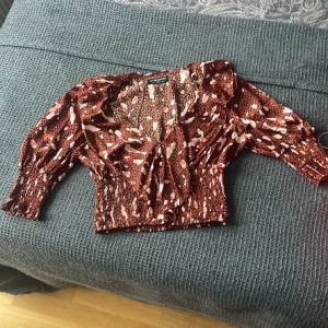 Blus  - V- ringad blus med volangkant. Bred resår längst ner och 3/4 ärm med resår . 