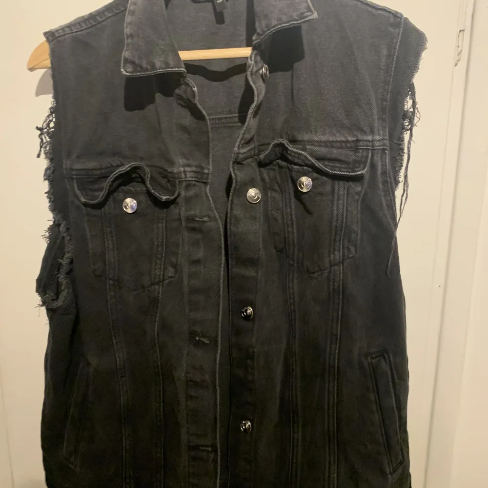 Svart jeans väst från H&M. Fint skick, ända grejen är att den är sliten vid ärmarna men det gör västen bara finare.  Originalpris: 399kr  Är S men sitter mer som ett M. Toppar.