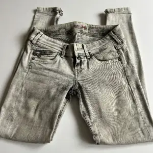 Tunna jeans med ett hål i skrevet som kan fixat genom att sy. Fina low waist byxor med detaljer. Även skinny. 