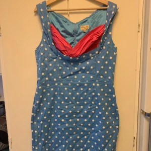 Klänning Lindy Bop - Åtsmitande stretchig klänning från retroinspirerade märket Lindy Bop. Väldigt bekväm och endast använd en gång. Fodringen ger en fin form på kroppen och jag tror att det skulle passa någon storlek upp eller ner
