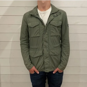 J.Lindeberg field jacket - Tja, säljer denna snygga field jacket från J.Lindeberg i väldigt bra skick och utan defekter förutom en väldigt liten skråma på själva märket. Nypris ligger på runt 2000kr. Skriv vid minsta fundering!