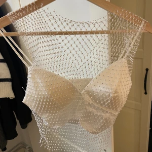 Fest topp - Säljer denna assnygga festtoppen, de är ett set med vit bas topp och en glittrigt ”nät” dem sitter inte ihop, men väljer att sälja dem ihop, då jag köpte toppen så!! Finns ingen lapp med storlek på plagget, men kan gissa att den är i storlek S!!😊