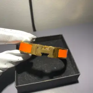 Ett Hermes armband i färgerna guld och orange. Är använt men väldigt försiktigt. Så den är som ny. Säljer för att jag inte använder det längre.  Skriv för frågor och funderingar!