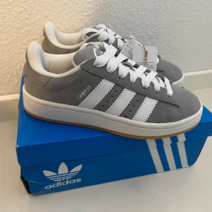Nya Adidas Campus 00s -storlek 36 grå - Adidas Originals Campus 00 s j Storlek: 36 Färg: Grå (Grey Three / Cloud White / Cloud White) Ingår både vita och gråa skosnören.  Nya och oanvända. Ligger kvar i kartong.  (Ganska stora i storlek)