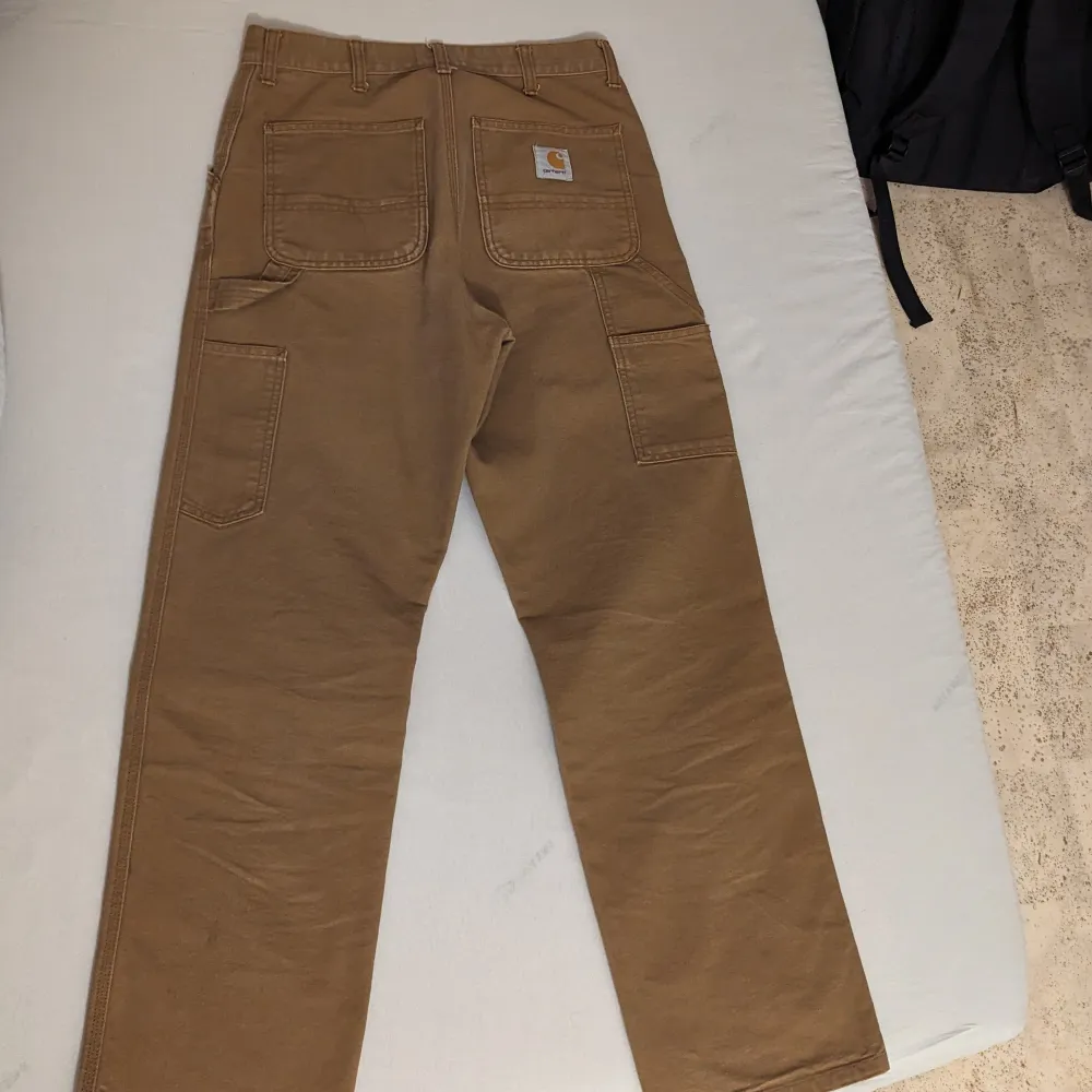 Carhartt single knee i Harrington brown. Köptes runt ett år sen men användes inte särskilt mycket då de är för korta nu. Original pris 1300kr.. Jeans & Byxor.