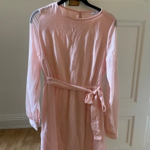 Rosa klänning - Rosa klänning i mesh-material. Har ett band som går att knyta precis som man vill. Passar perfekt till sommaren! 
