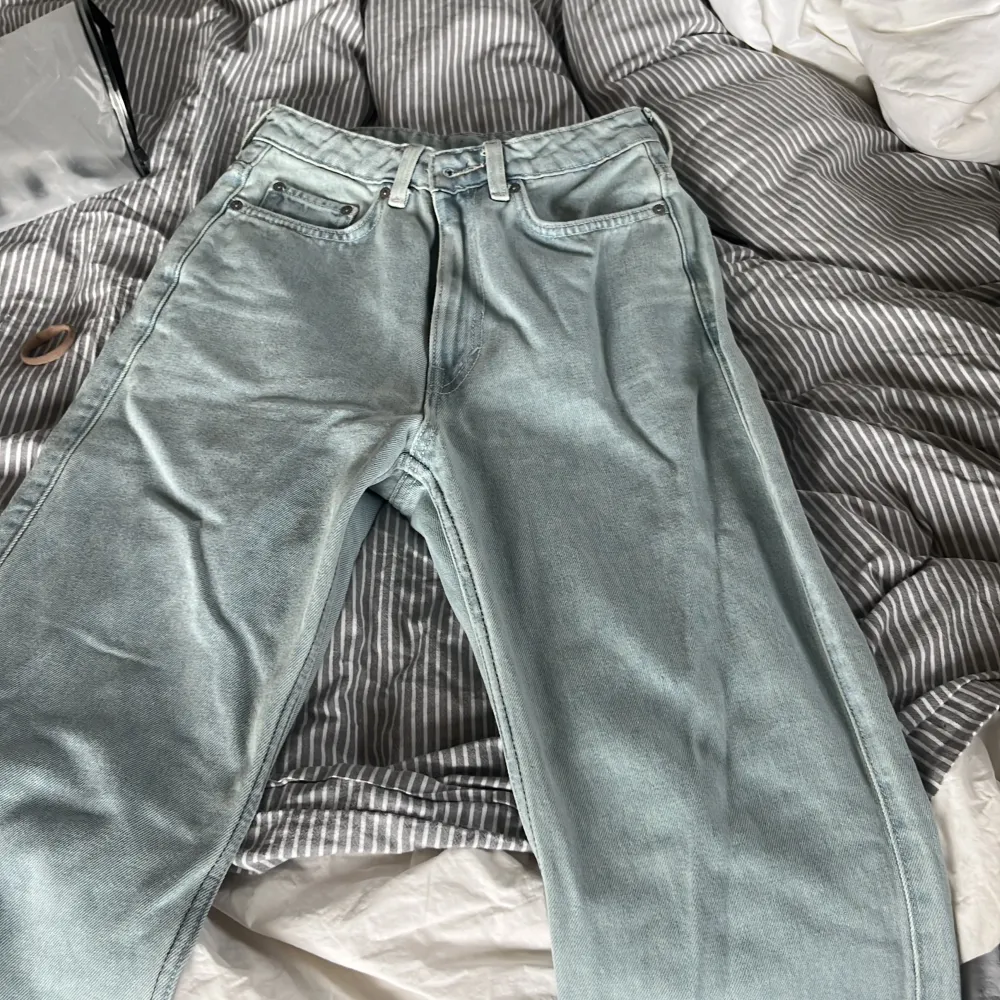 Ljusblå jeans med slits från weekday i modellen rowe. Storlek 26. Jeans & Byxor.
