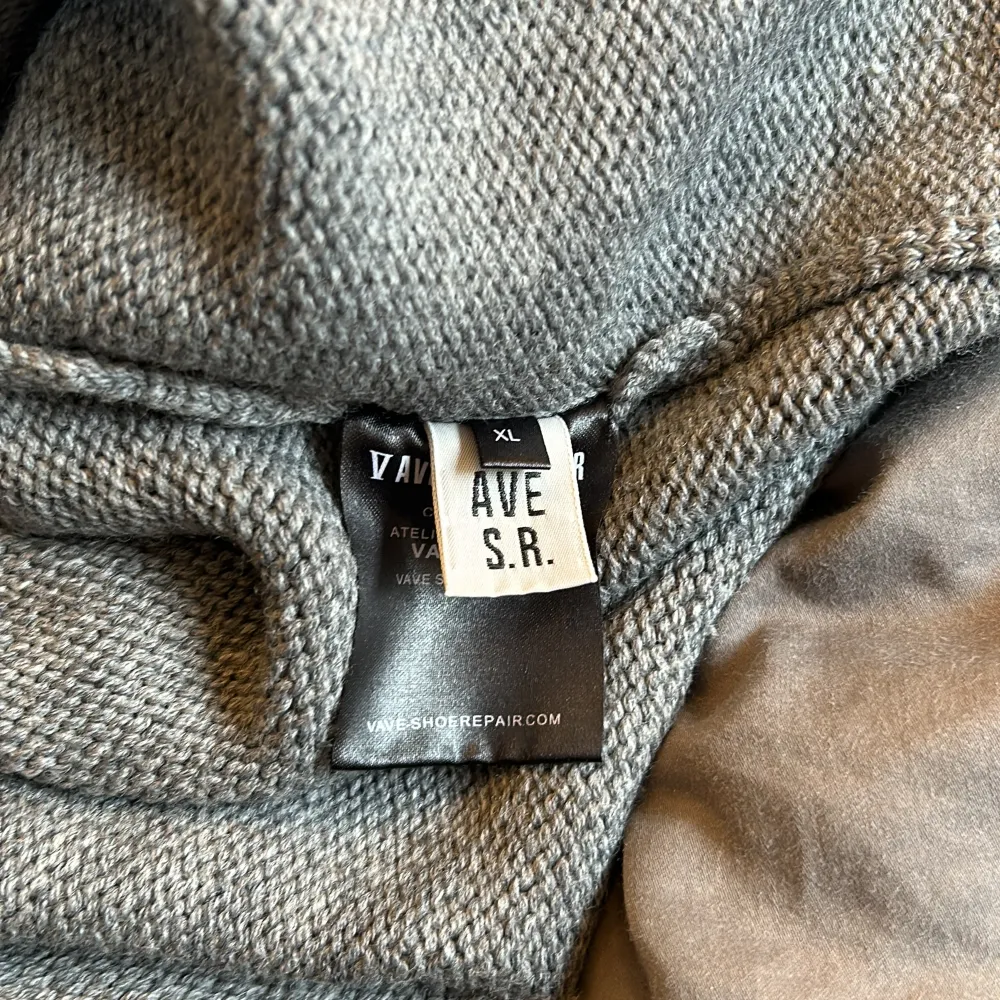 Grå stickad tröja i 100% ull/ylle. Fina detaljer. Använd fåtal ggr. En liten fläck på mage . Stickat.