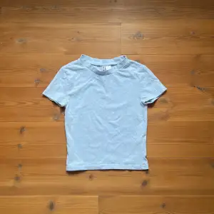 Kort, tajt t-shirt i en klar ljusblå färg. Fint skick och i princip helt oanvänd. Mjukt material och tajt!
